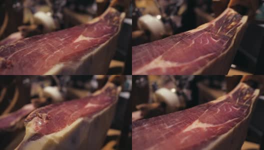 Jamon塞拉诺。传统西班牙火腿在市场上收市。桌上的猪腿火腿。餐厅内部的美食肉。整个火腿放在架子上。多莉高清在线视频素材下载