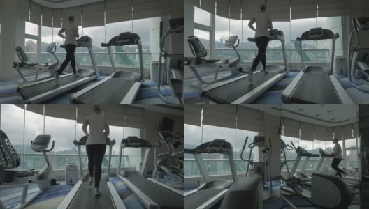 女人在全景窗口前跑步机上锻炼高清在线视频素材下载