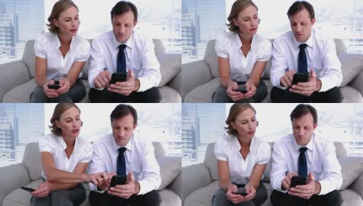 女商人向同事展示如何使用智能手机高清在线视频素材下载