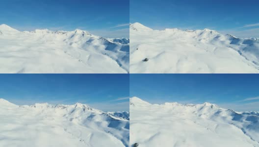 在蓝天下，用无人机飞越雪山。法国的山顶被雪覆盖着。冬天的白色风景令人放松，非常适合极限运动。高清在线视频素材下载