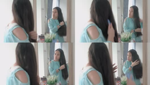 一个年轻女子早晨在镜子前梳头发高清在线视频素材下载