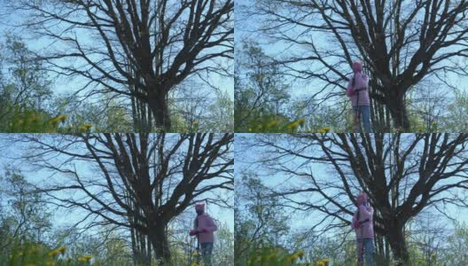 戴面具的女学生驾驶摩托车经过一棵大的光秃秃的树高清在线视频素材下载