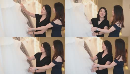 亚洲的中国女新娘和伴娘正在婚纱店为她的婚礼寻找完美的婚纱高清在线视频素材下载