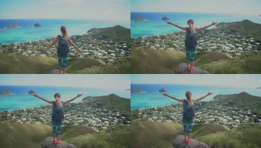 美国夏威夷瓦胡岛山顶上俯瞰大海的年轻女子张开双臂高清在线视频素材下载