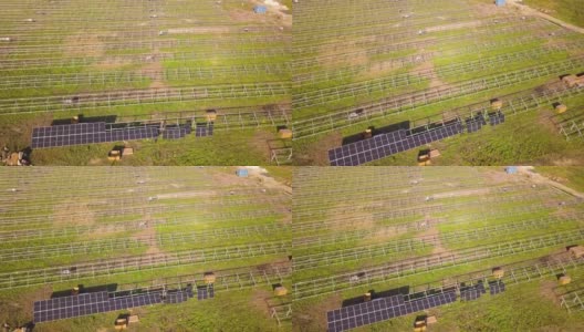 鸟瞰图:绿色土地上在建的太阳能发电厂。生产清洁生态能源的电板组装高清在线视频素材下载