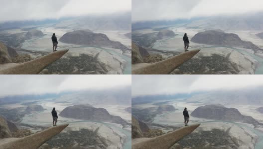 一个人站在岩石上，看着喜马拉雅山上的河流高清在线视频素材下载