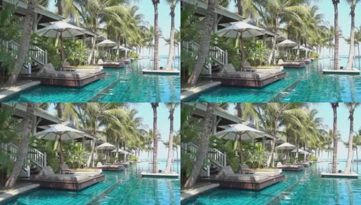 游泳池与热带棕榈树和海滩高清在线视频素材下载