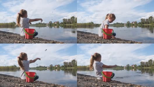 小女孩在沙滩上玩耍，往河里扔石头。研究大自然的细节。高清在线视频素材下载