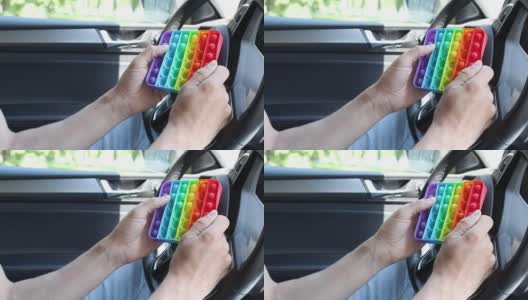一个男人坐在车里玩一个抗压力玩具。通过玩耍来释放紧张和压力。高清在线视频素材下载