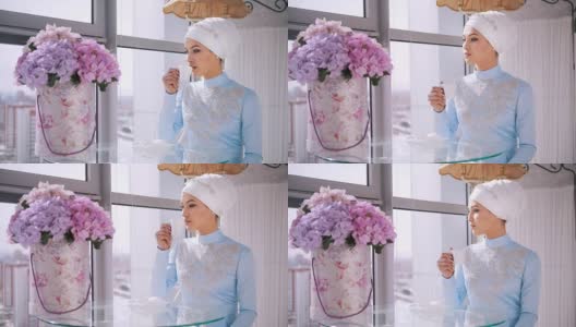 年轻的穆斯林新娘在蓝色婚纱喝一杯咖啡高清在线视频素材下载
