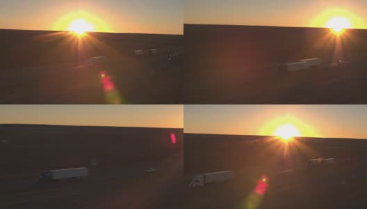 太阳升起时，用空中装载的半卡车在荒芜的国土上运送货物高清在线视频素材下载