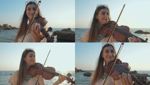 年轻漂亮的白人女人穿着牛仔裤在海滩上拉小提琴靠近美丽的大海或海洋，慢镜头高清在线视频素材下载