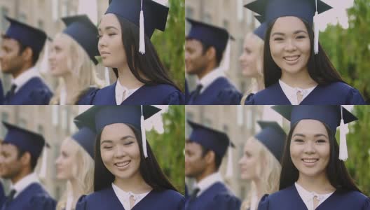 在毕业典礼上，亚洲女孩在照相机前微笑高清在线视频素材下载