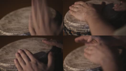 一个男人的手在一个非洲皮肤覆盖的手鼓上敲出一个节拍。高清在线视频素材下载