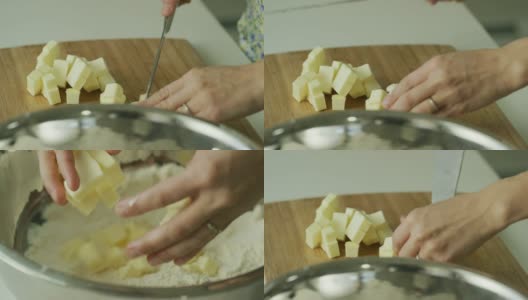 一个年轻女人的手用一把大菜刀把黄油切成小块，拿起黄油，撒在一个金属搅拌碗里的面粉上高清在线视频素材下载
