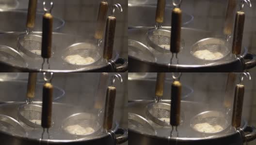 慢镜头日本厨师用滤过的肉汤在火锅上煮饺子。高清在线视频素材下载