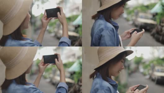 一名亚洲女子戴着复古软呢帽，在泰国曼谷的一条小街上用智能手机拍照，享受东南亚暑假旅游假期。高清在线视频素材下载