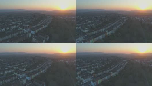 在英国布里斯托尔，空中飞过一排一排彩色梯田的郊区房屋，朝向夕阳高清在线视频素材下载
