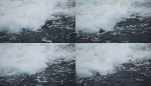 水快速下落的特写。河水的波浪、浪花和泡沫。瀑布从上面。在自然的力量。高清在线视频素材下载