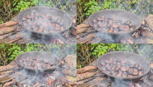用特制的钢锅在火上烤栗子和马罗尼。传统的意大利秋季美食户外烹饪。高质量的全高清镜头。软焦点高清在线视频素材下载