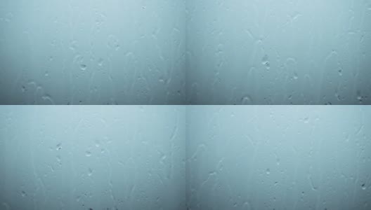 雨的背景，雨滴顺着玻璃流下，美丽的雨滴倾盆而下，窗外是雷雨。高清在线视频素材下载