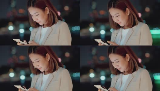 美丽的亚洲女人发短信给她的丈夫在晚上加班后的手机。高清在线视频素材下载