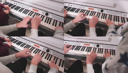 成人和儿童的手在钢琴键上练视唱练耳课。高清在线视频素材下载