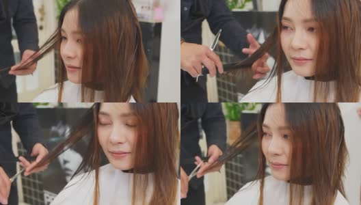 专业男性发型师在美容院为女性理发。理发师用剪刀把坐在店里对着镜子微笑的年轻亚洲女孩剪了下来。美容院的经营理念。高清在线视频素材下载