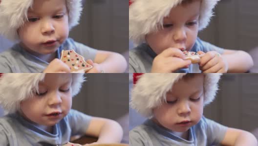 3岁的小男孩圣诞老人戴着红色的帽子吃圣诞饼干高清在线视频素材下载