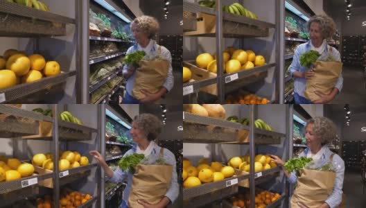 老妇人在有机食品市场购物，看着货架上食物的价格，然后选择水果高清在线视频素材下载