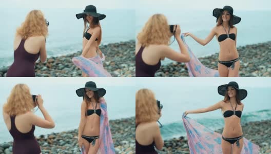 两个穿着泳衣的女性朋友在海滩上拍照。复古的概念高清在线视频素材下载