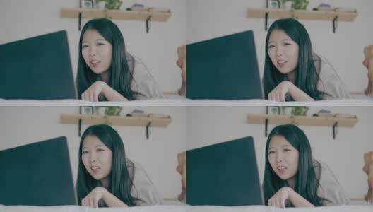 亚洲妇女使用笔记本电脑进行视频会议和在床上工作-股票视频高清在线视频素材下载