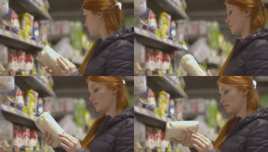 漂亮的红头发女人在超市买大米高清在线视频素材下载