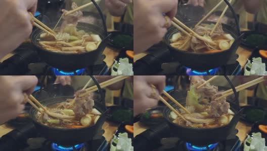 一家人在日本餐馆吃涮涮锅晚餐。和家人一起吃涮锅饭。高清在线视频素材下载