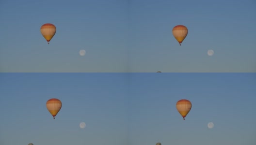 在卡帕多西亚的山丘间，热气球在满月下飞行高清在线视频素材下载