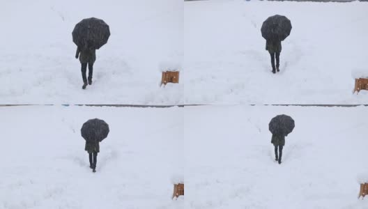 一个男人在大雪中撑着伞走高清在线视频素材下载