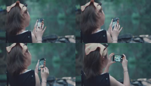一个女人用智能手机拍摄美丽的森林。高清在线视频素材下载