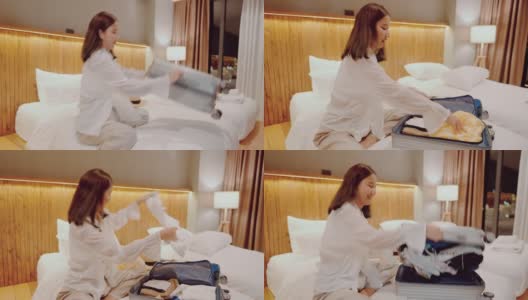 美丽的女人在舒适的酒店房间的床上打开行李箱。高清在线视频素材下载