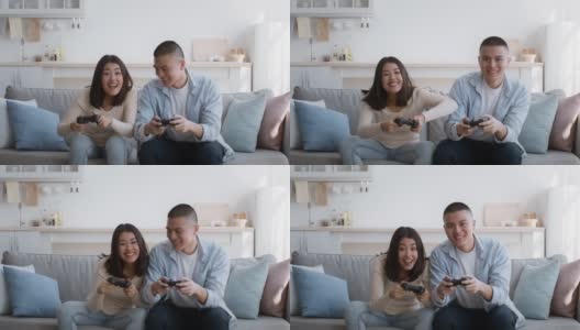 快乐的中国夫妇玩电子游戏在家里玩得开心高清在线视频素材下载
