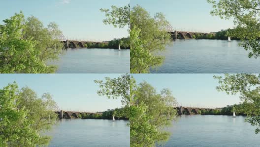 在第聂伯罗河上观看日出日落时移动的钓鱼帆船。城市湖上工业桥景观。在晴朗的夏日，卡车和汽车经过池塘水上运输，旅行高清在线视频素材下载