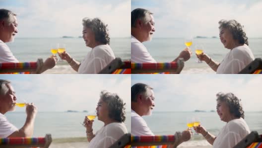 亚洲老年夫妇在夏天度假时在海滩上喝酒高清在线视频素材下载