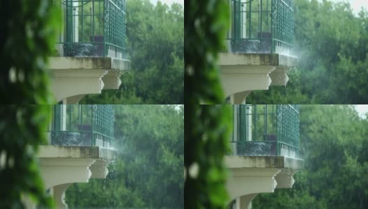 倾盆大雨在家庭阳台露台，即将到来的夏季风暴高清在线视频素材下载