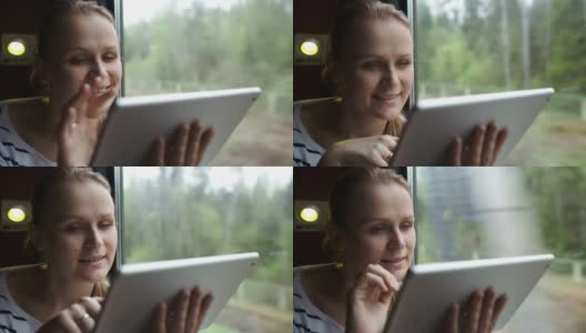 年轻女子用触摸板坐在窗边高清在线视频素材下载