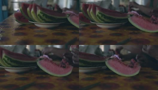 特写镜头:切成片熟透的西瓜放在盘子里的桌子上高清在线视频素材下载
