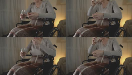 悲伤的老婆婆坐在轮椅上吃药，恢复期，抑郁高清在线视频素材下载