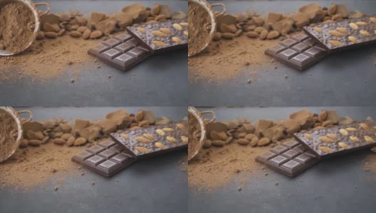 用杏仁做巧克力棒，甜点，手工糖果。由牛奶和黑巧克力块组成，可可粉在黑色背景上。桌上的糖果工艺品高清在线视频素材下载