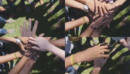所有种族和颜色的手臂堆叠在一起，一个一个的团结和团队合作，然后升起。许多多种族的手聚在一个圆圈的中心，然后欢呼。户外特写高清在线视频素材下载