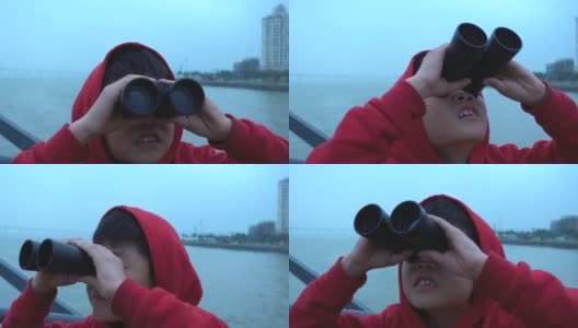 小男孩在游船上用双筒望远镜看高清在线视频素材下载