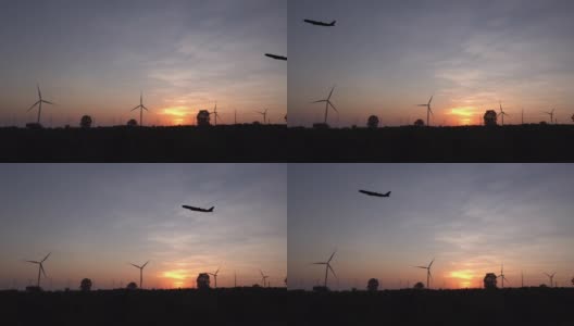 飞机与风力涡轮机在日落。高清在线视频素材下载