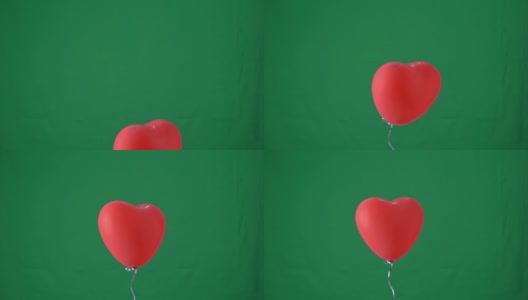 红色心形氦气球孤立在绿色屏幕背景上，情人节，生日派对设计概念，4K，工作室拍摄，慢动作。高清在线视频素材下载